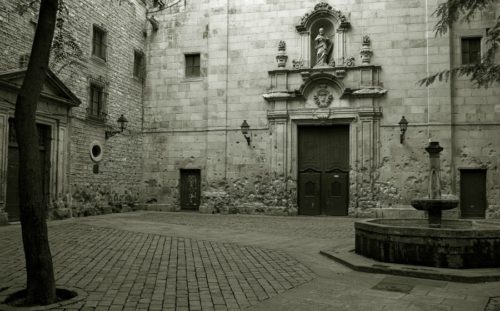 Plaça de Sant Felip Neri i Barcelona. Muren ved kirkedøren viser stadig sporene af de heftige kampe i borgerkrigens sidste dage i centrum af byen. 